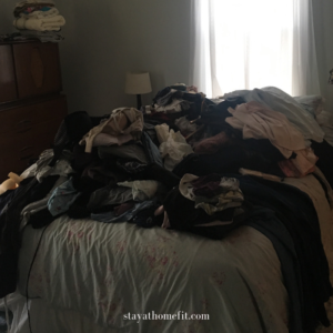 photo of bed with large pile of clothing on it